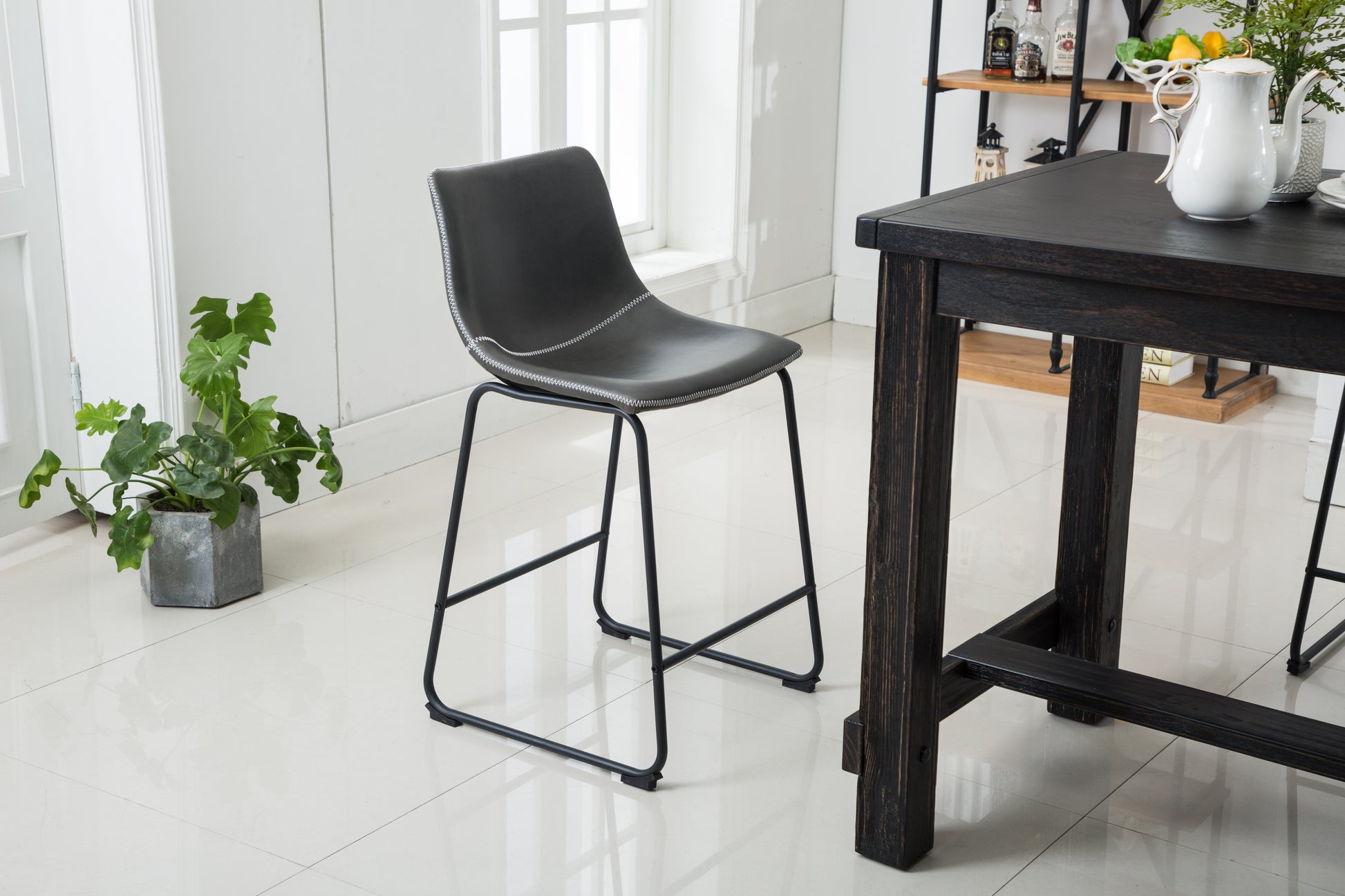 Dark gray faux leather bar stool with white stitching and black metal legs