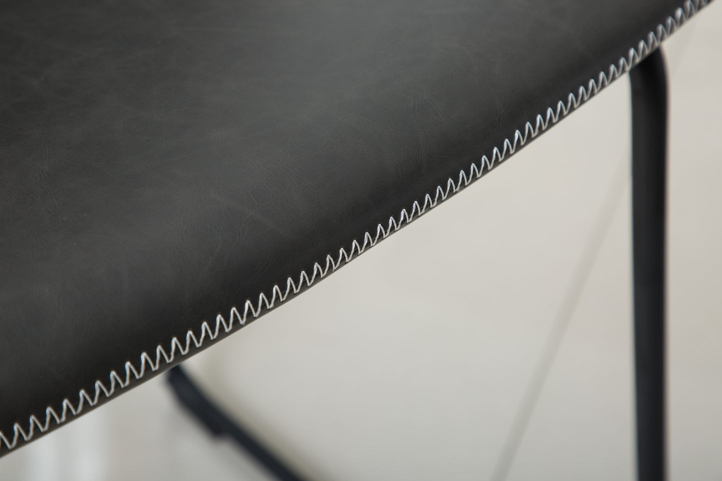 Black faux leather seat with white contrast stitching