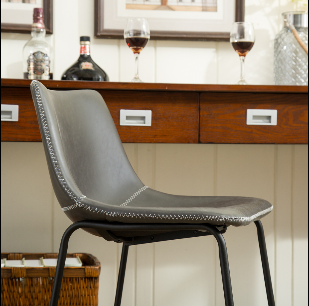 Gray upholstered dining chair with white stitching and black metal legs