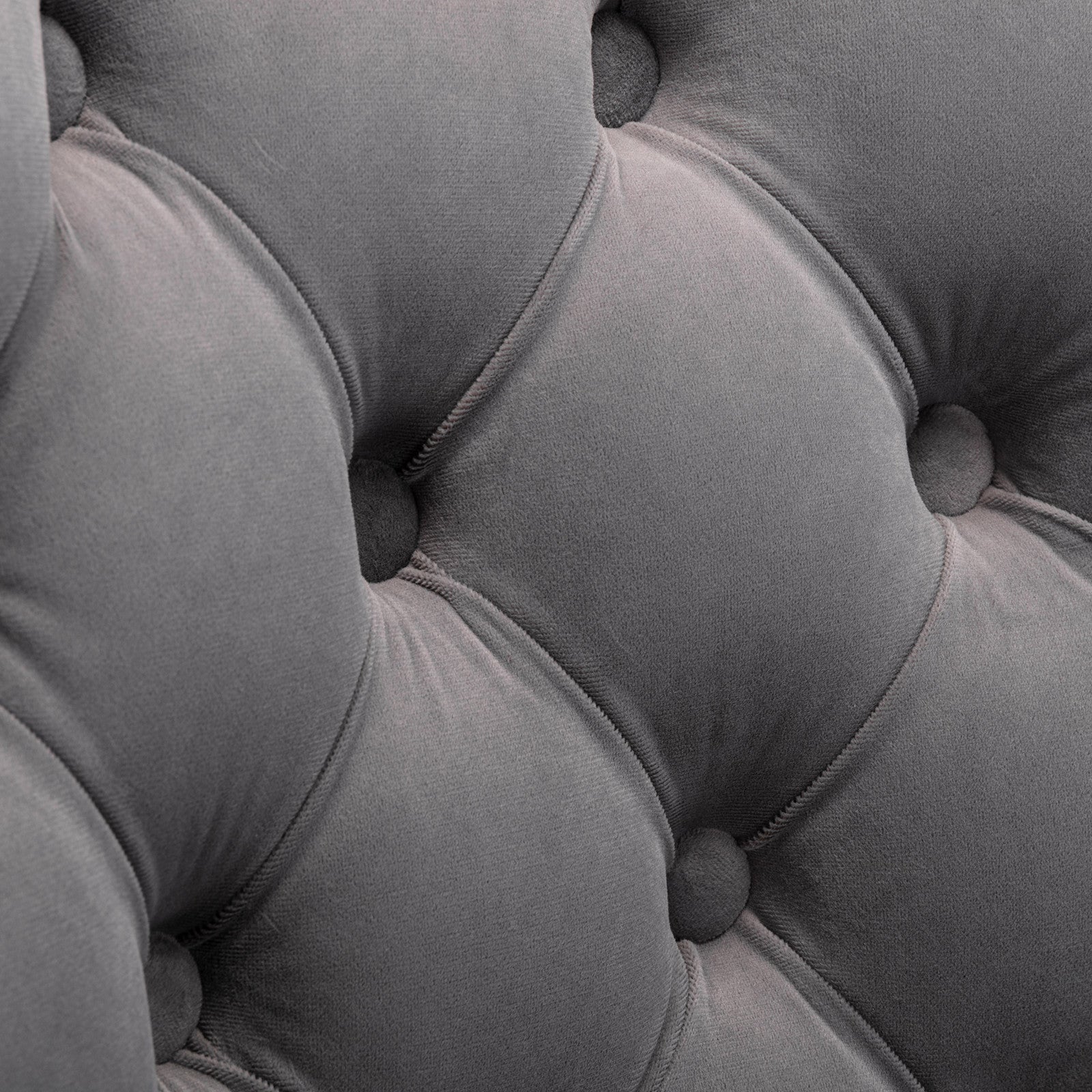 Closeup of tufted grey velvet upholstery