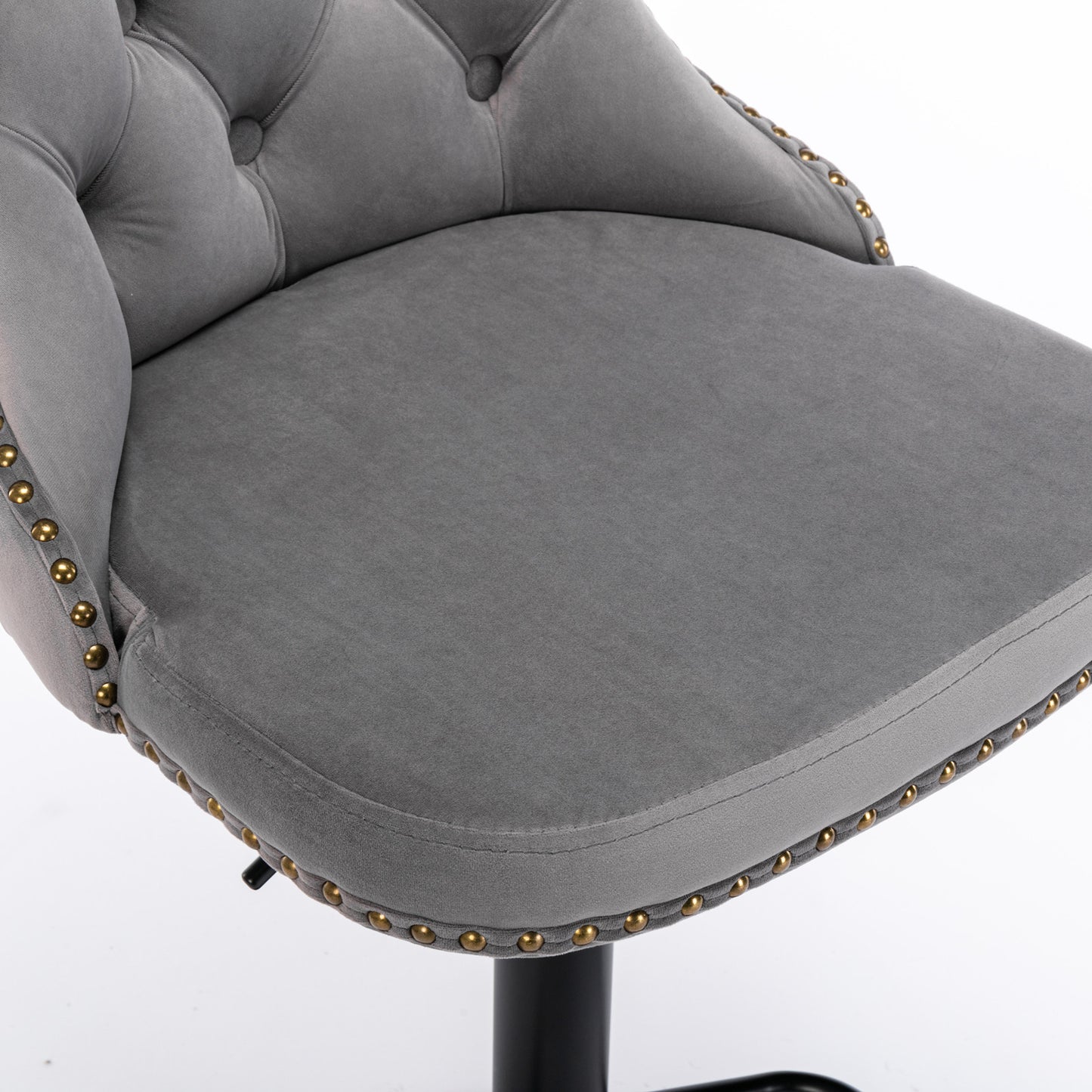 Closeup of grey velvet tufted bar stool seat with gold nailhead trim