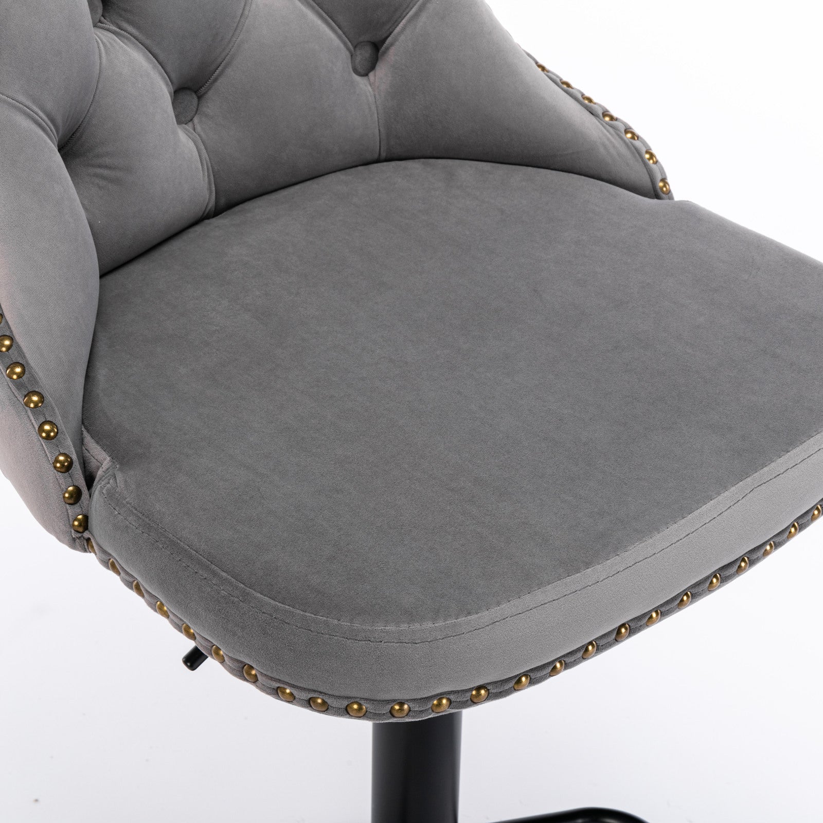 Closeup of grey velvet tufted bar stool seat with gold nailhead trim
