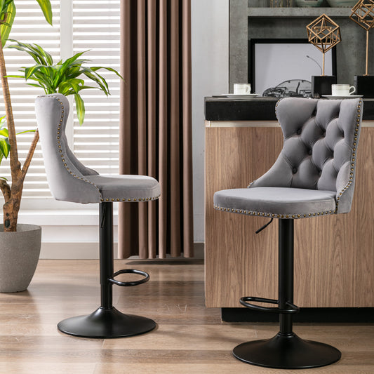 Tufted grey velvet bar stool with brass nailhead trim and adjustable height