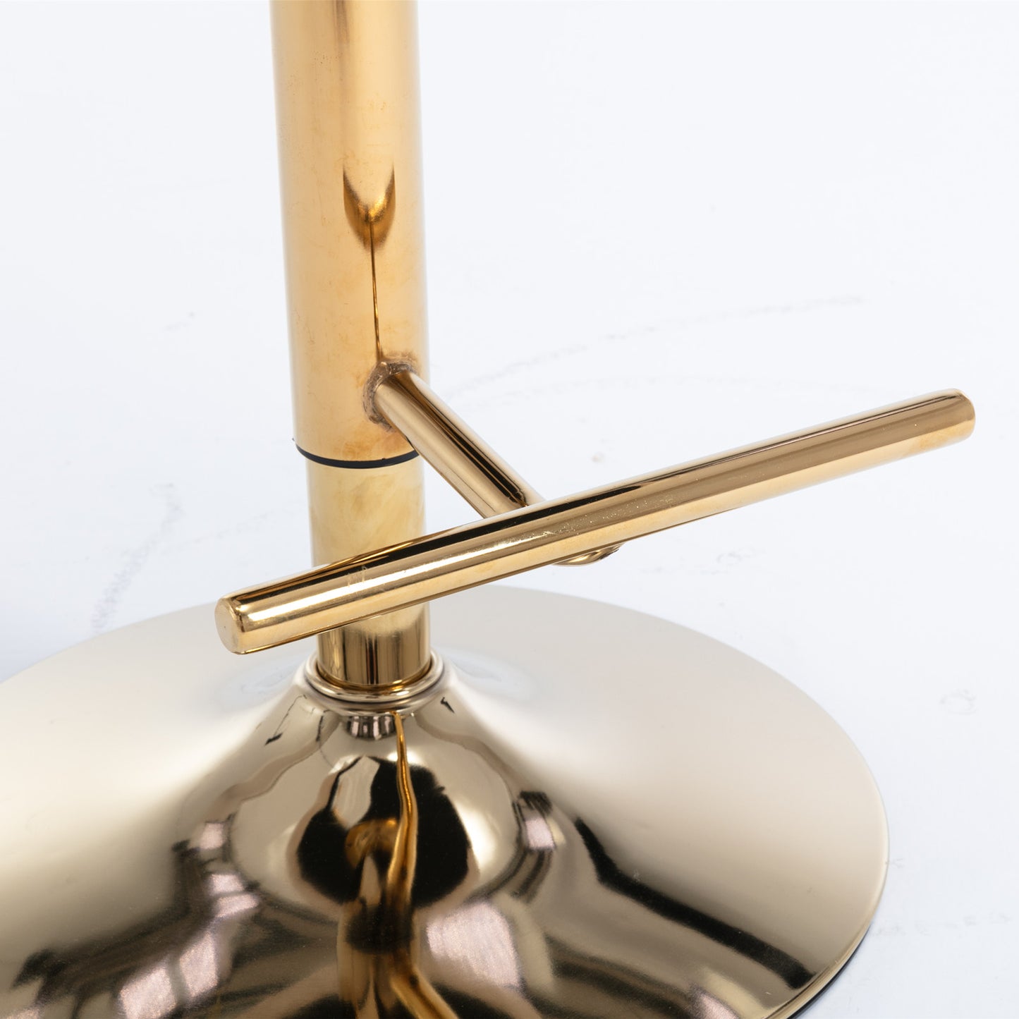 Closeup of shiny gold bar stool base with footrest