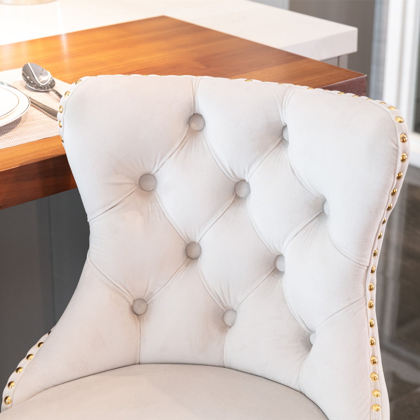 Light grey velvet dining chair with tufted back and gold nailhead trim