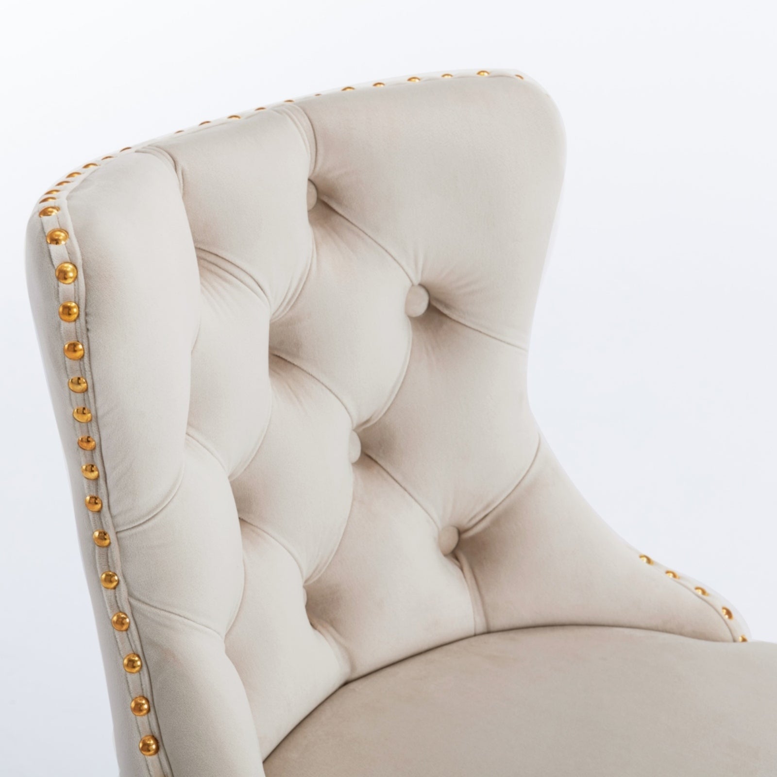 Cream velvet accent chair with tufted back and gold nailhead trim
