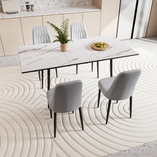 Modern white marble dining table with black legs and four grey upholstered chairs