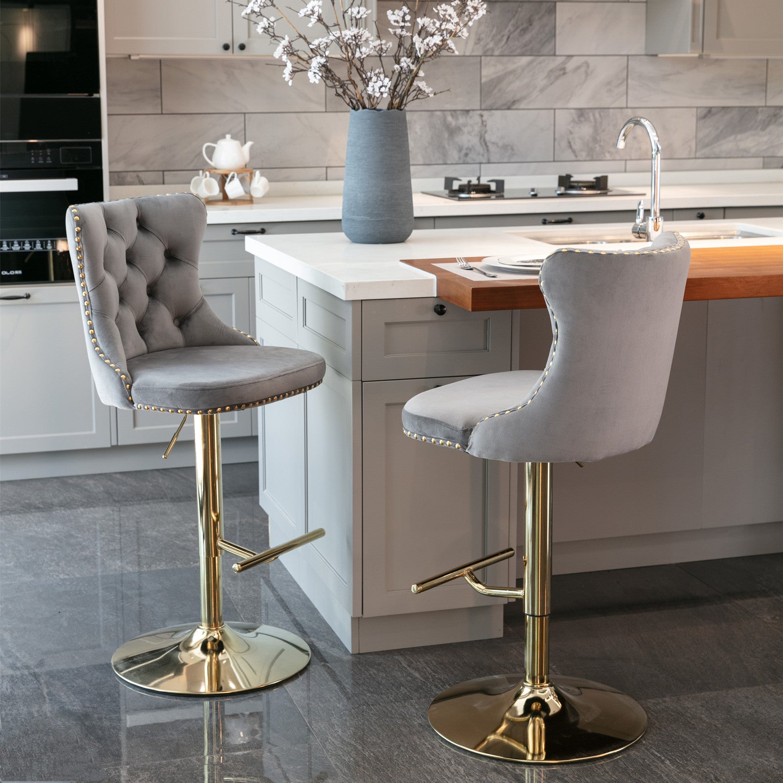 Tufted grey velvet bar stool with gold studded trim and a polished gold base