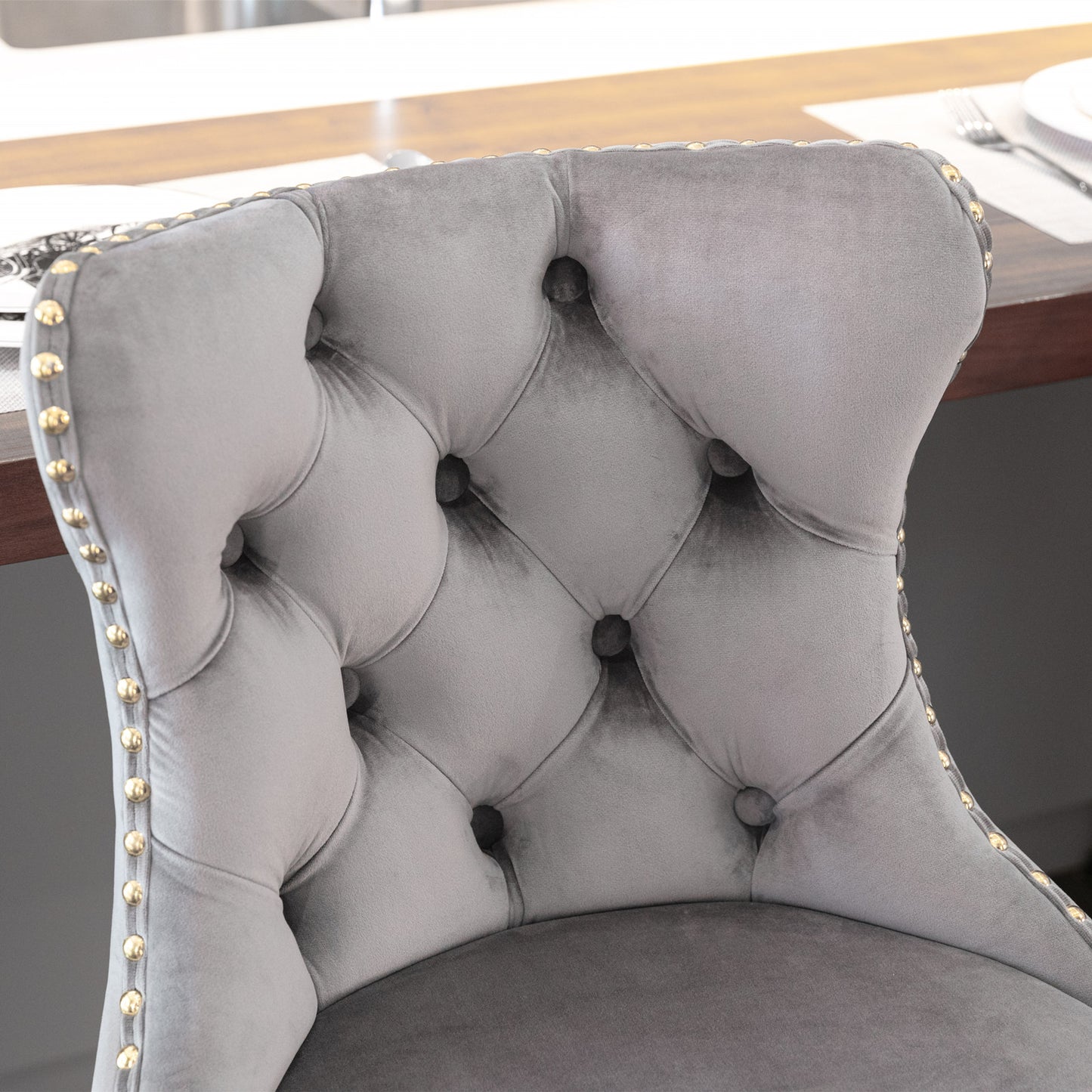 Tufted gray velvet dining chair with gold nailhead trim