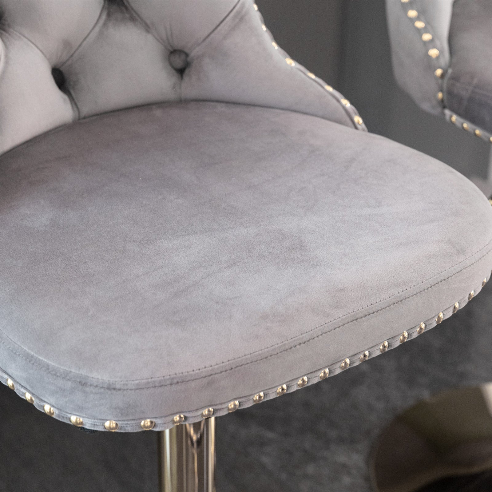 Grey velvet bar stool with gold stud accents and tufted back detail