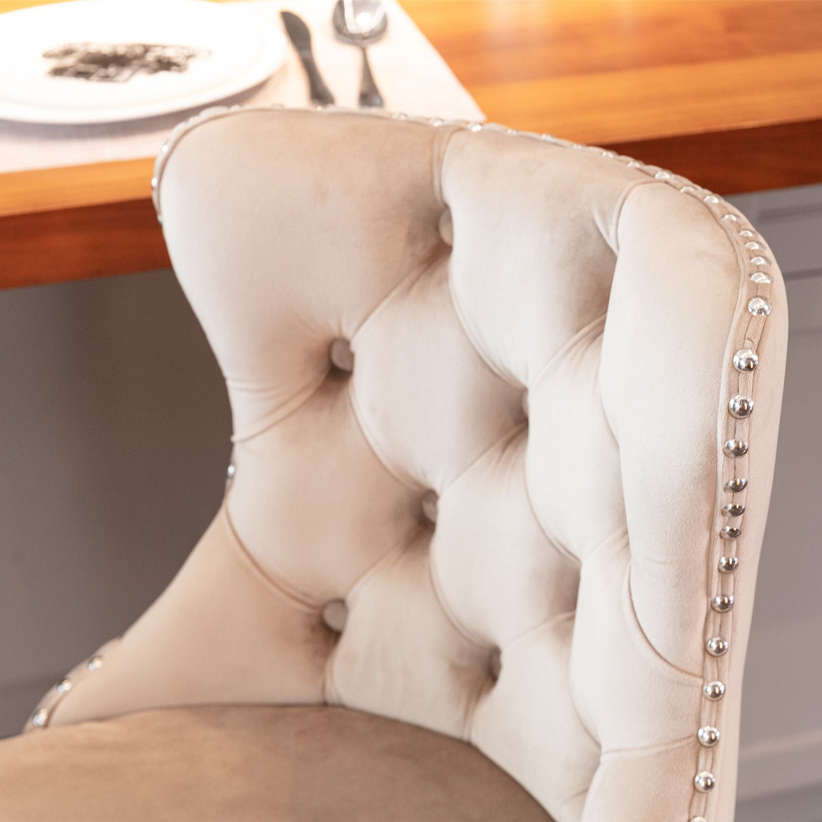 Beige velvet accent chair with button tufting and silver nailhead trim