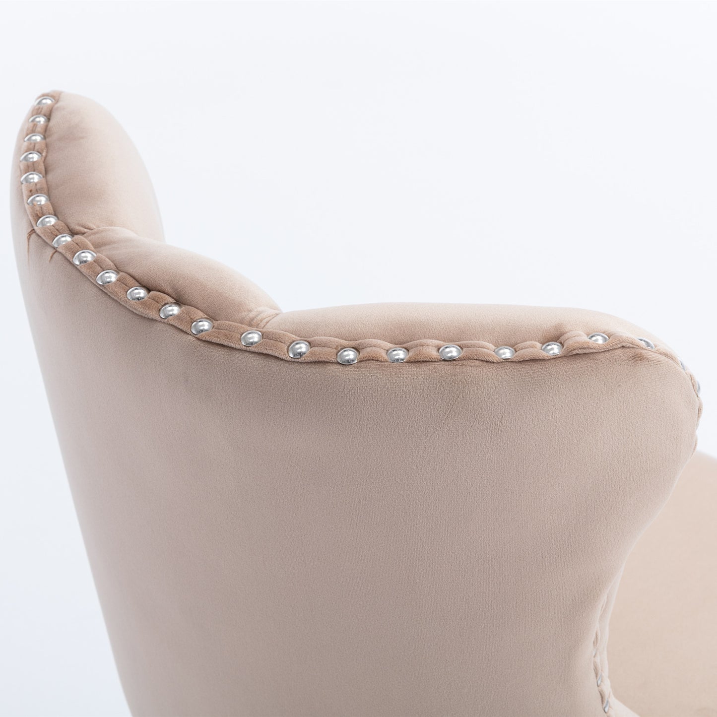 Beige velvet armchair detail with silver nailhead trim accents and button tufting