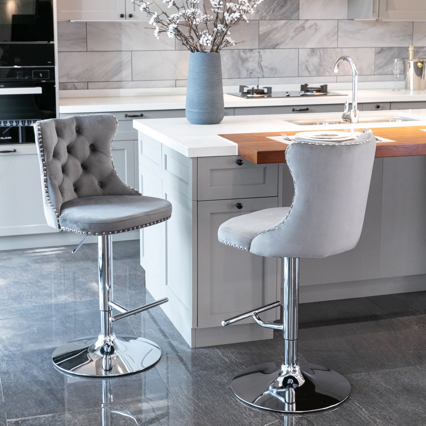 Grey velvet tufted bar stool with silver nailhead trim and chrome base