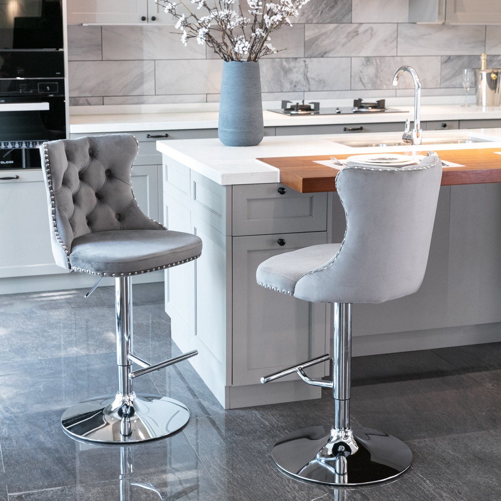 Grey velvet tufted bar stool with silver nailhead trim and chrome base