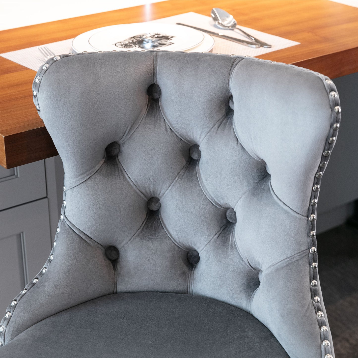 Grey velvet tufted dining chair with silver nailhead trim