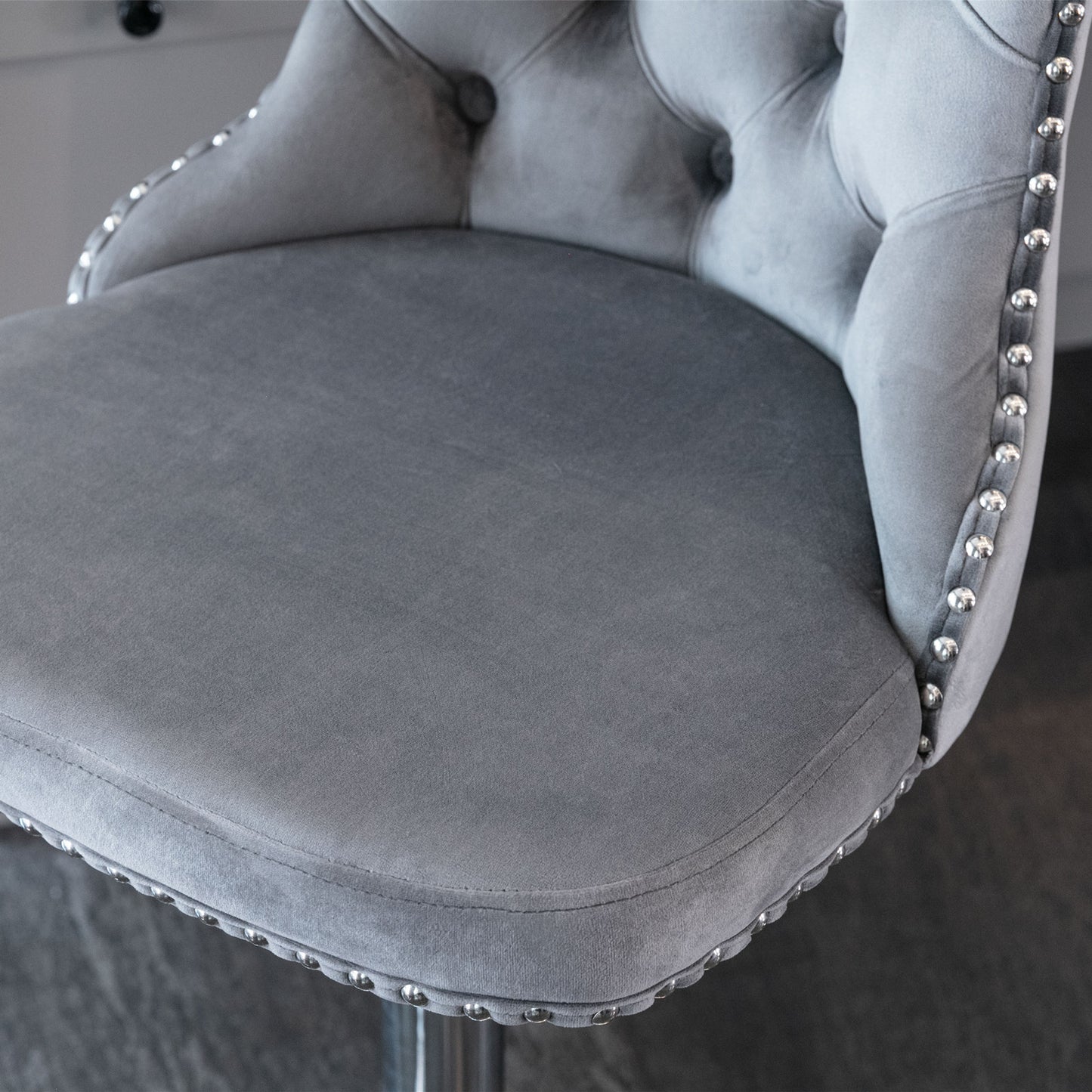 Grey velvet bar stool with button tufting and silver nailhead trim