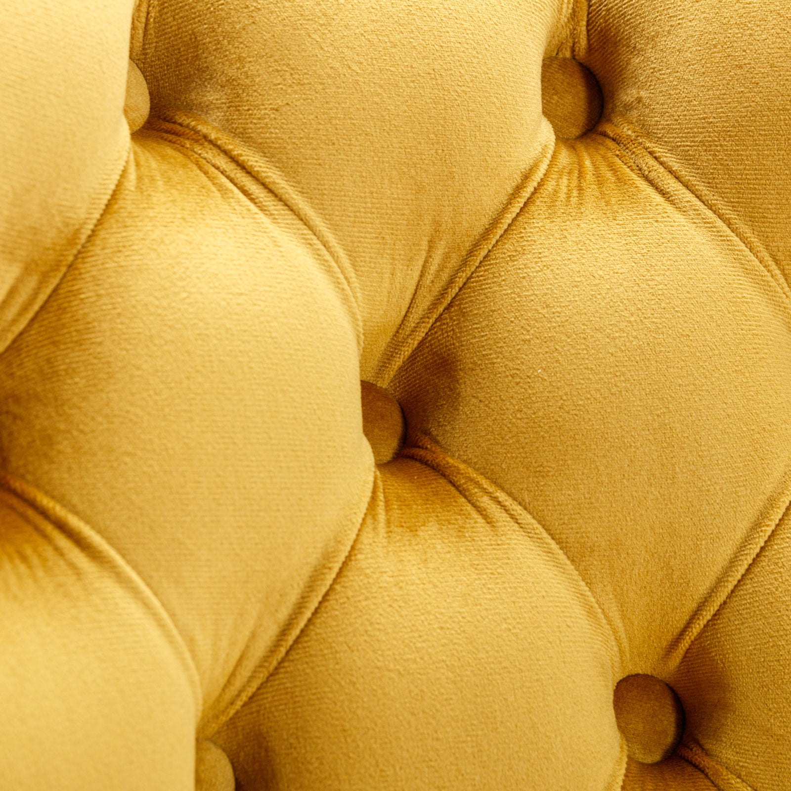 Closeup of mustard yellow velvet tufted upholstery fabric with diamond stitching