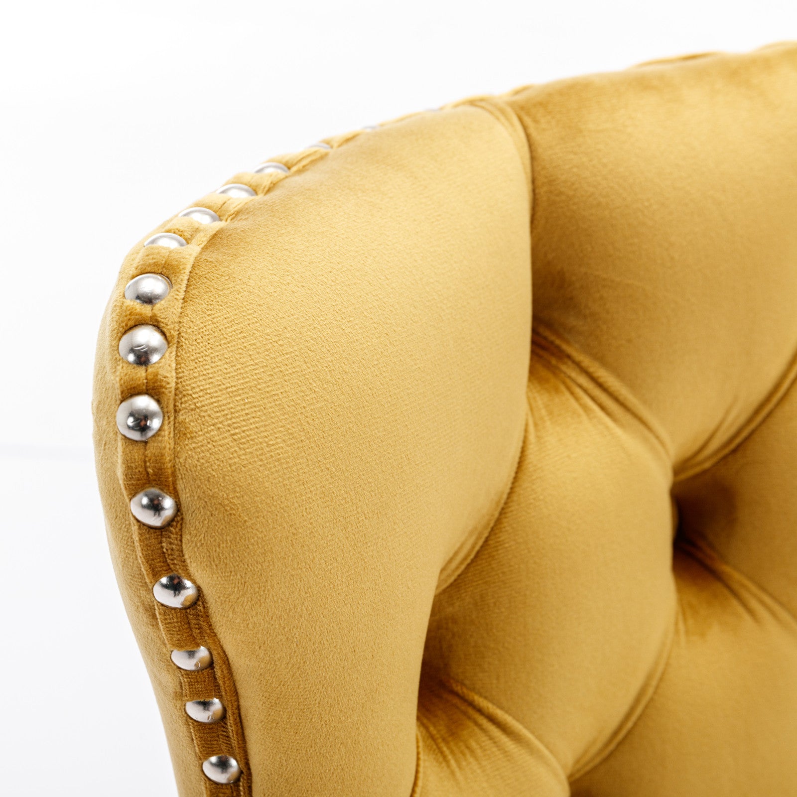 Yellow velvet armchair detail with silver nailhead trim