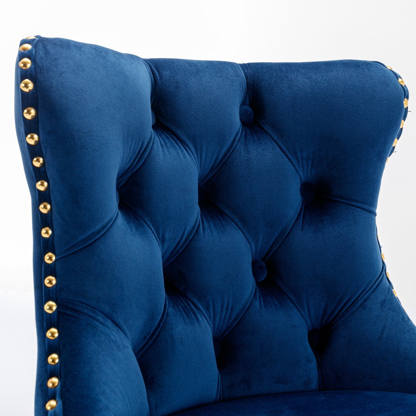Deep blue velvet armchair with tufted back and gold nailhead trim