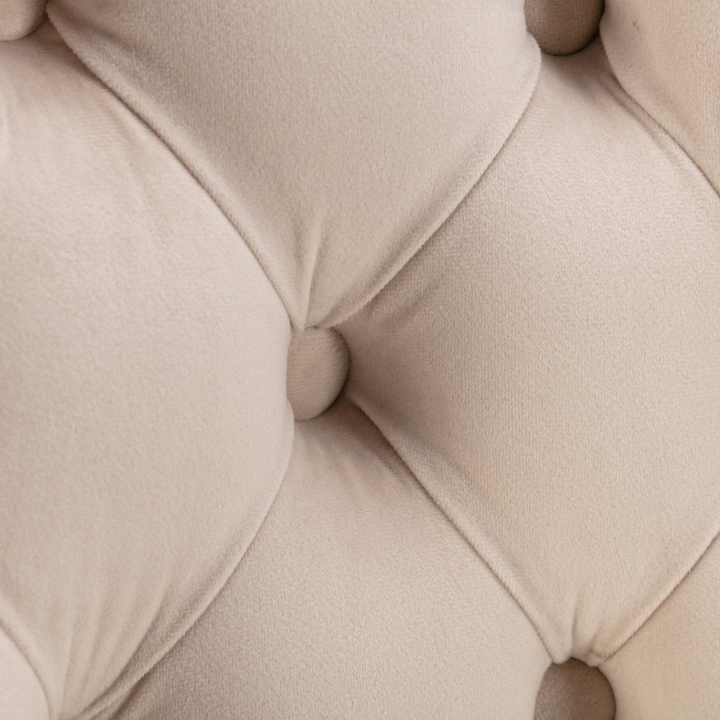 Closeup of beige tufted velvet upholstery with diamond stitching