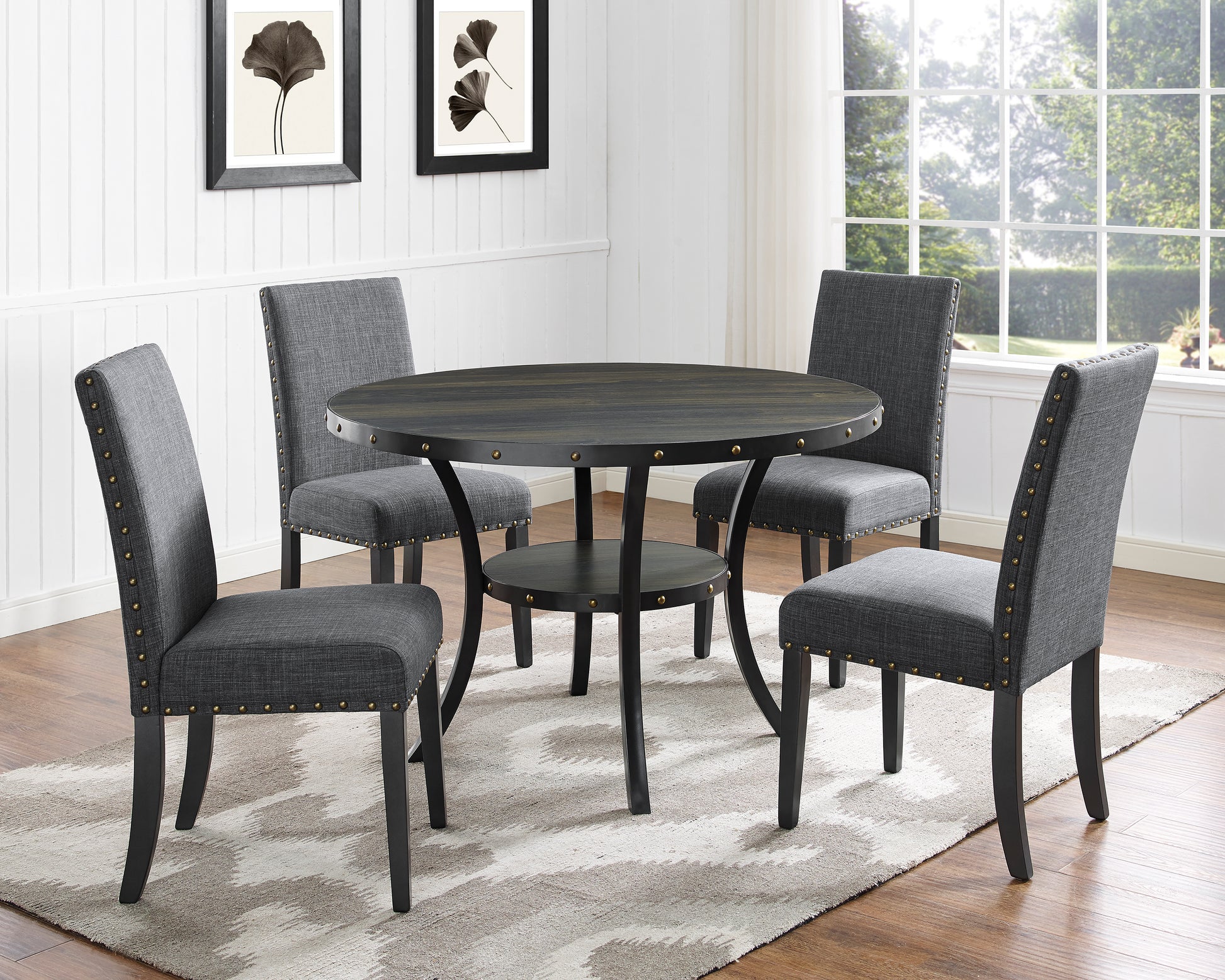 Dark wood round dining table with four upholstered gray chairs