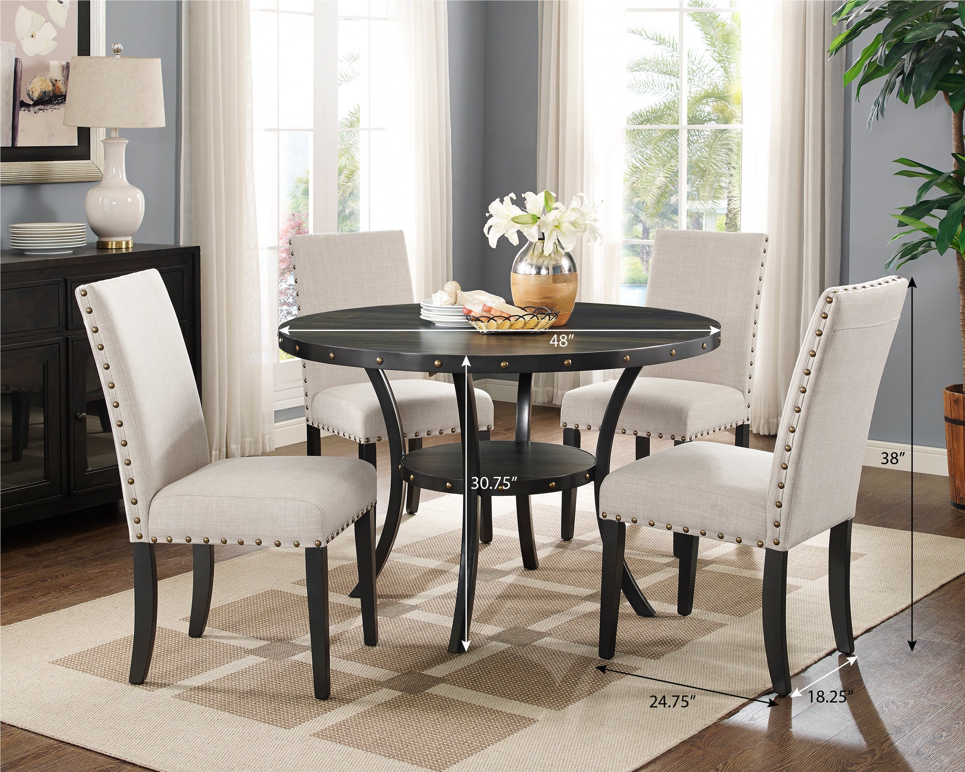 Round dining table with four upholstered chairs and nailhead trim