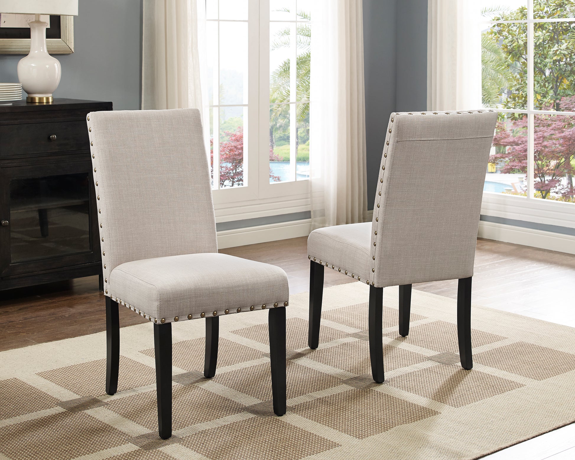 Light gray linen dining chair with nailhead trim and dark legs