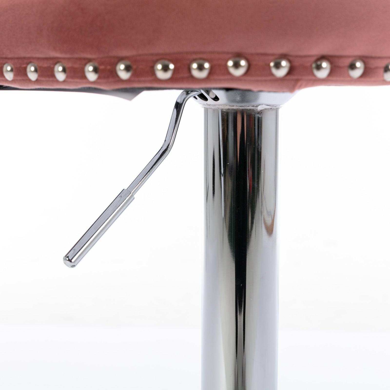 Closeup of rose gold velvet bar stool seat edge with nailhead trim and chrome lever