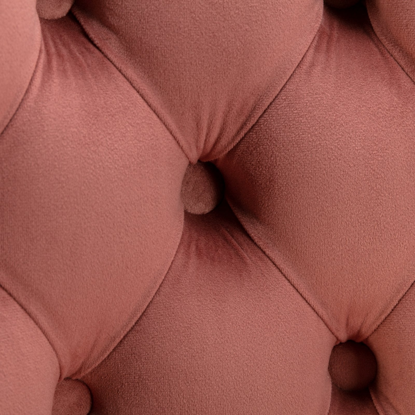 Rose velvet upholstery with diamond tufting on a luxury armchair