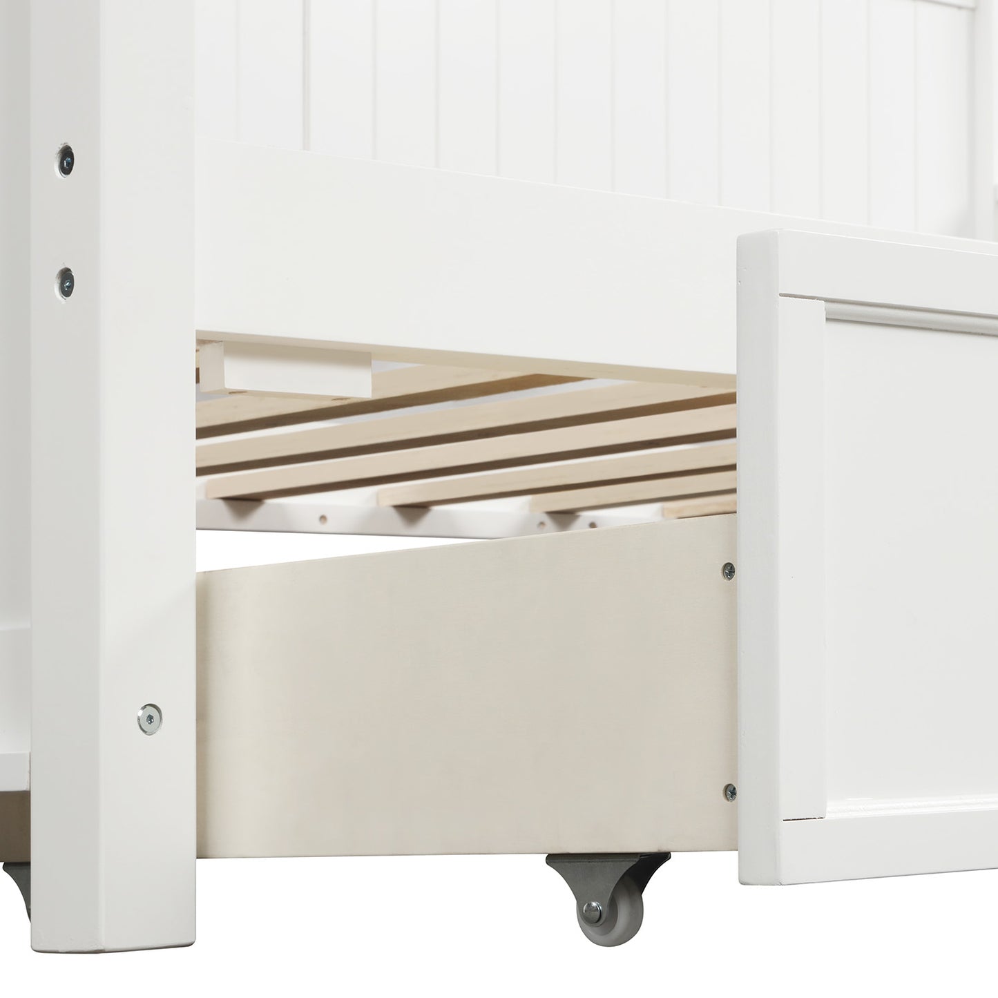 Closeup of white wooden bed frame detail with slatted base and open storage drawer