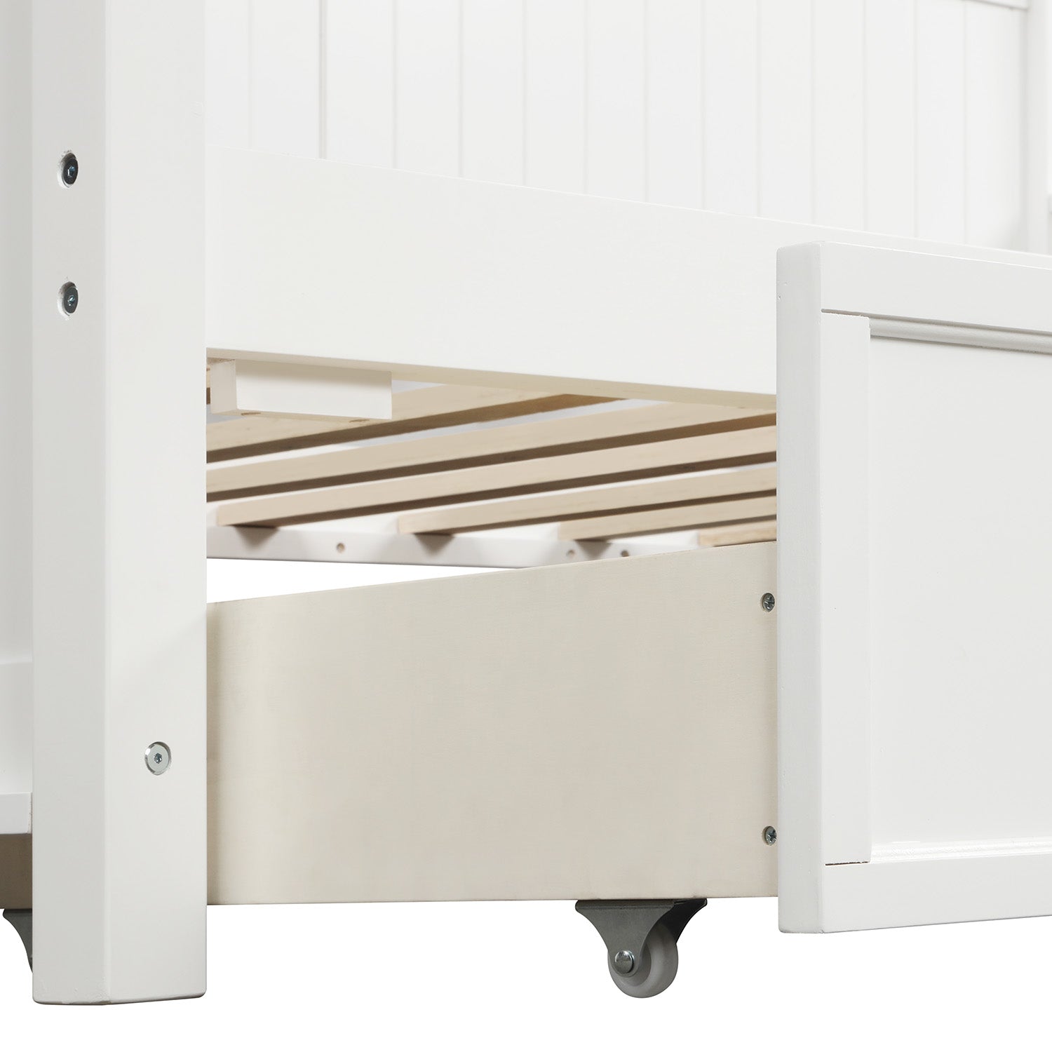 Closeup of white wooden bed frame detail with slatted base and open storage drawer