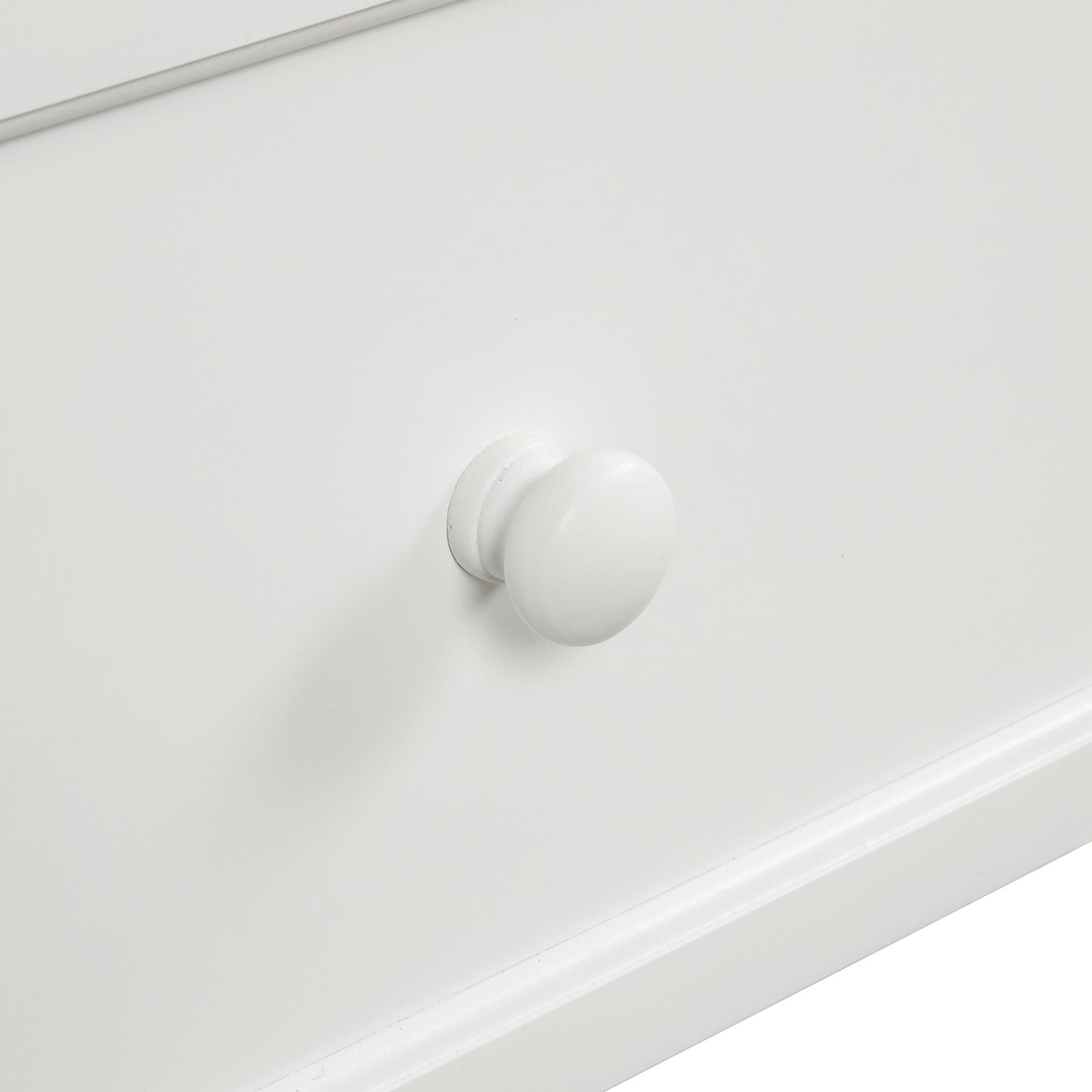 Closeup of a smooth white wooden drawer knob on a white dresser front