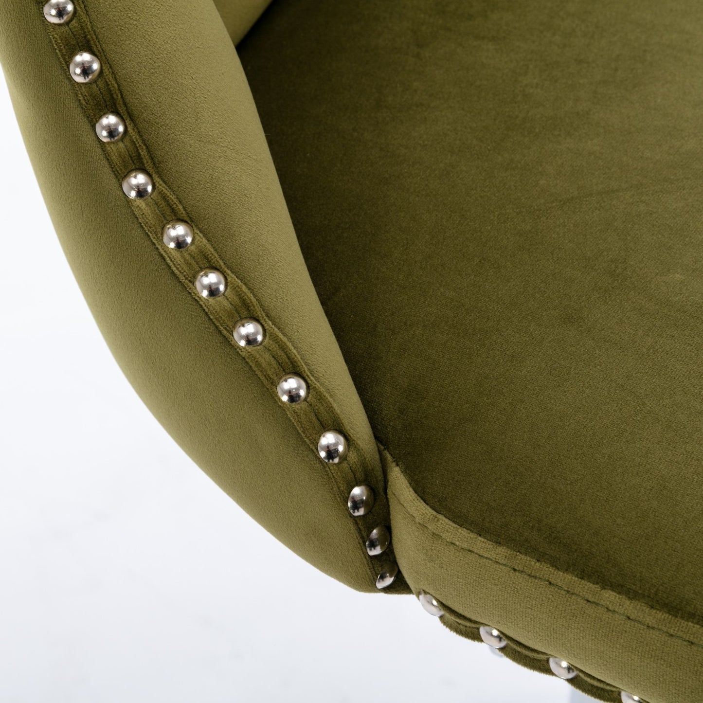 Close up of olive green velvet armchair with silver nailhead trim