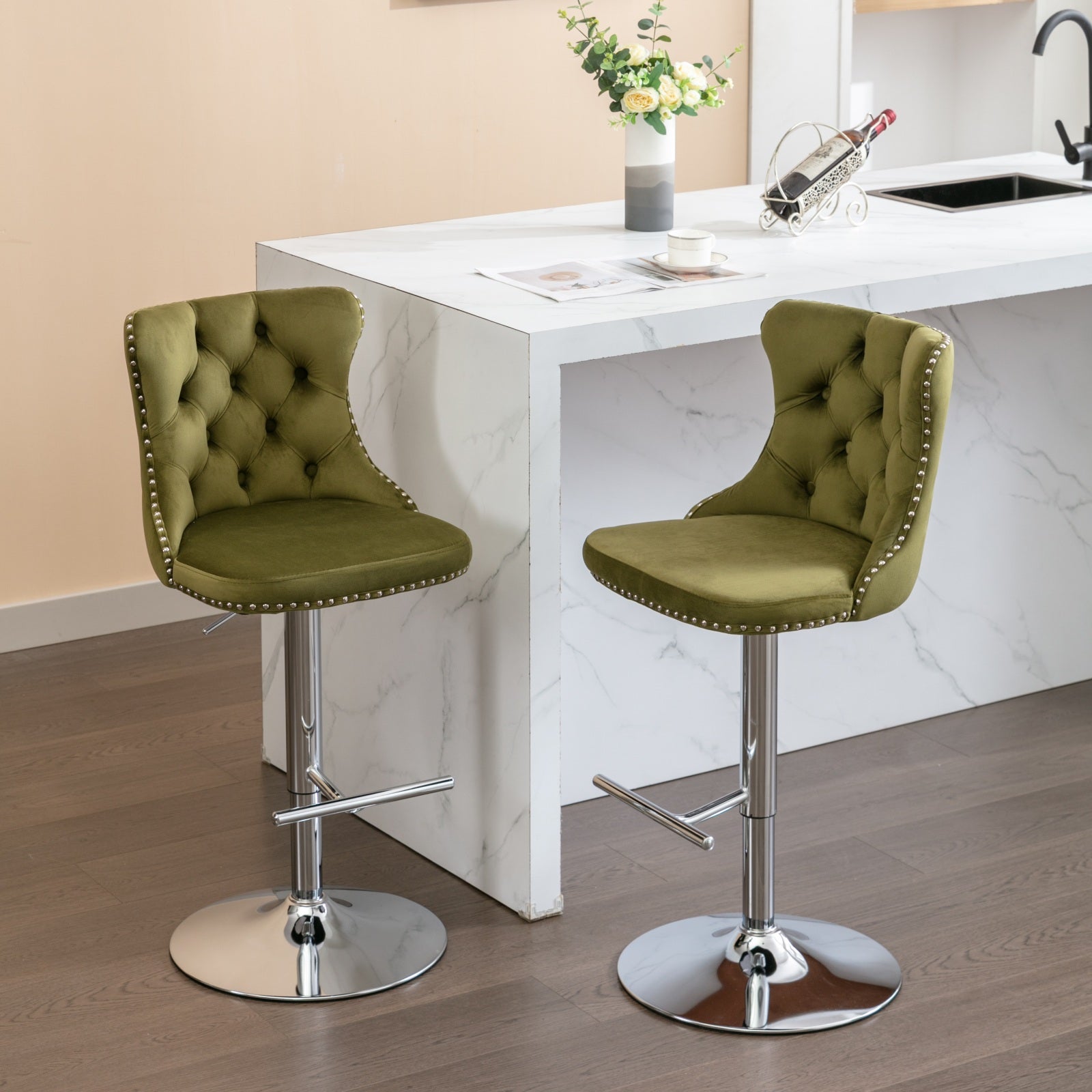 Two olive green velvet tufted bar stools with chrome accents