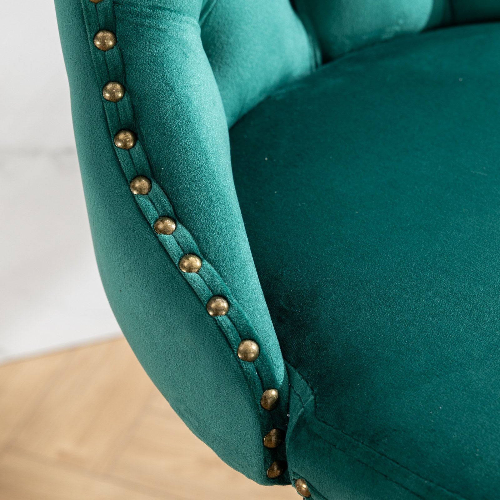 Emerald green velvet armchair with brass nailhead trim detail