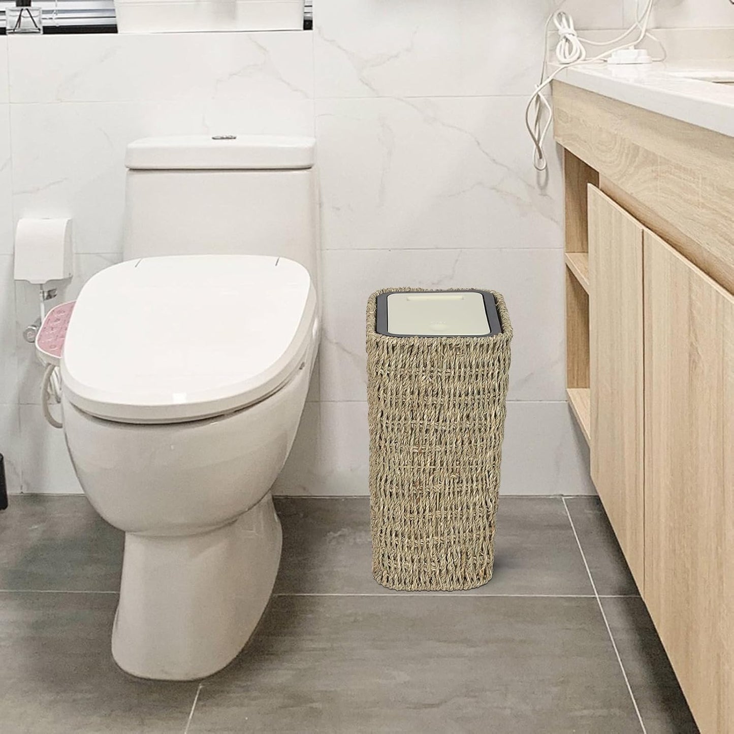 Woven seagrass trash can with lid in bathroom