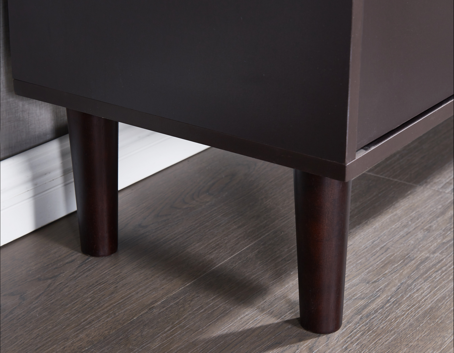 Dark brown particle board cabinet with tapered wooden legs