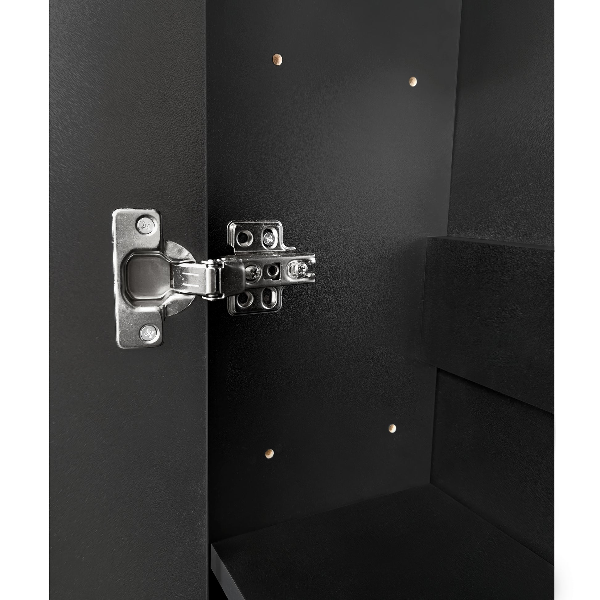 Closeup of a black cabinet door interior with a silver hinge