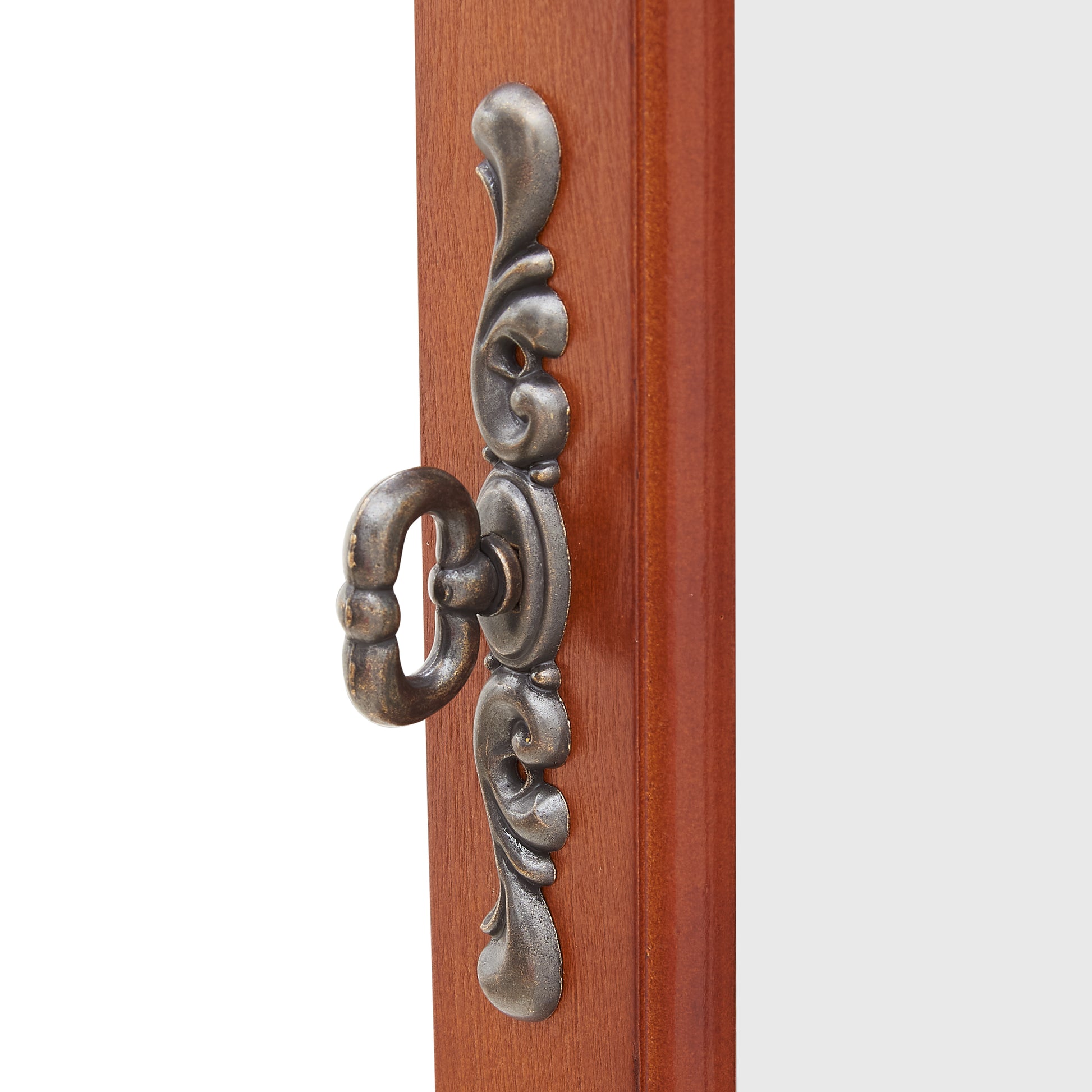 Antique brass ornate pull handle on wooden drawer