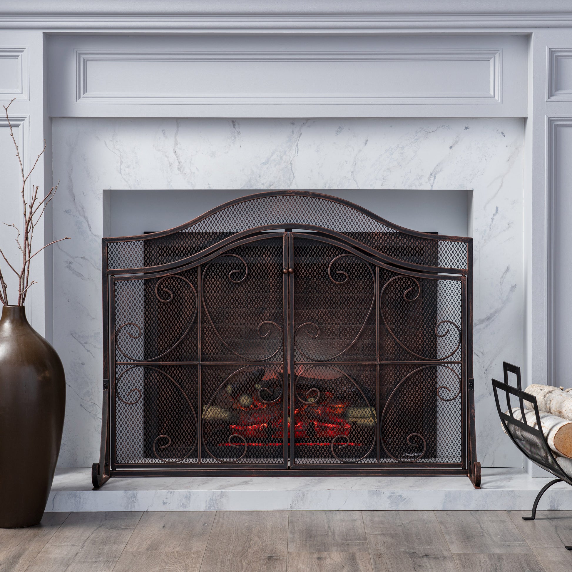 Ornate bronze metal fireplace screen with dual doors and scrollwork