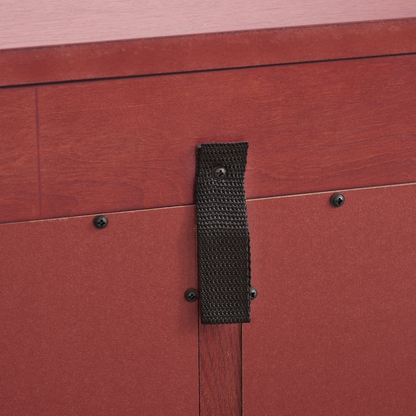 Closeup of mahogany wood drawer front with black nylon strap hardware