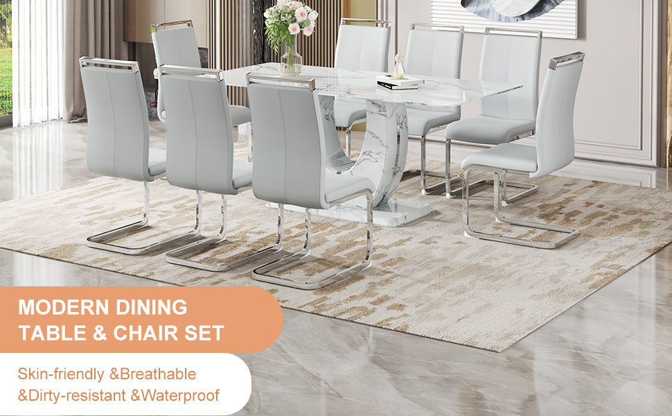Light gray leather dining chairs with chrome legs around a marblelook table
