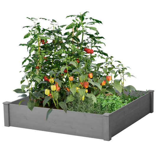 Gray wooden raised garden bed overflowing with ripe red tomatoes and colorful bell peppers