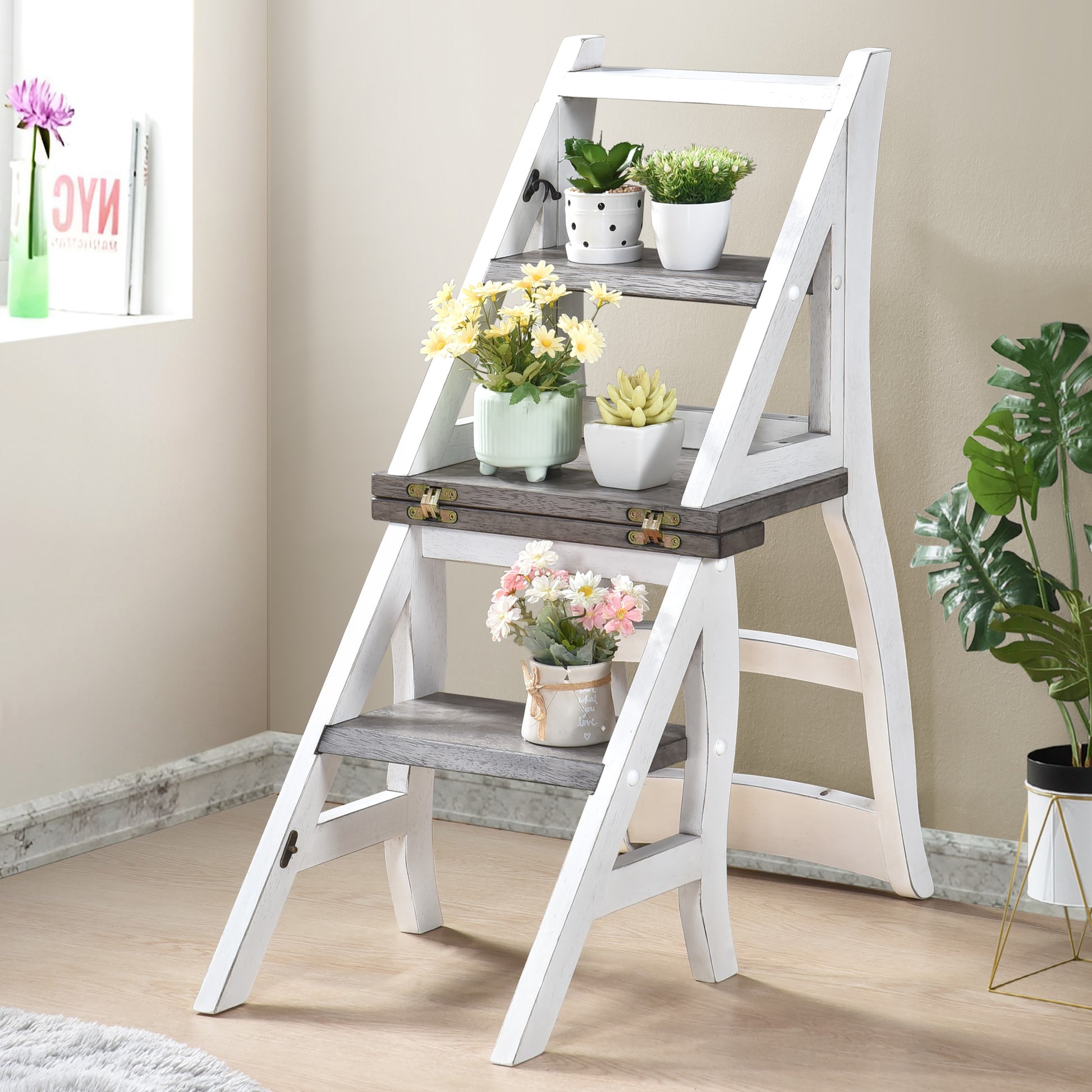 White wooden step stool with three shelves adorned with potted plants and decorative flowers
