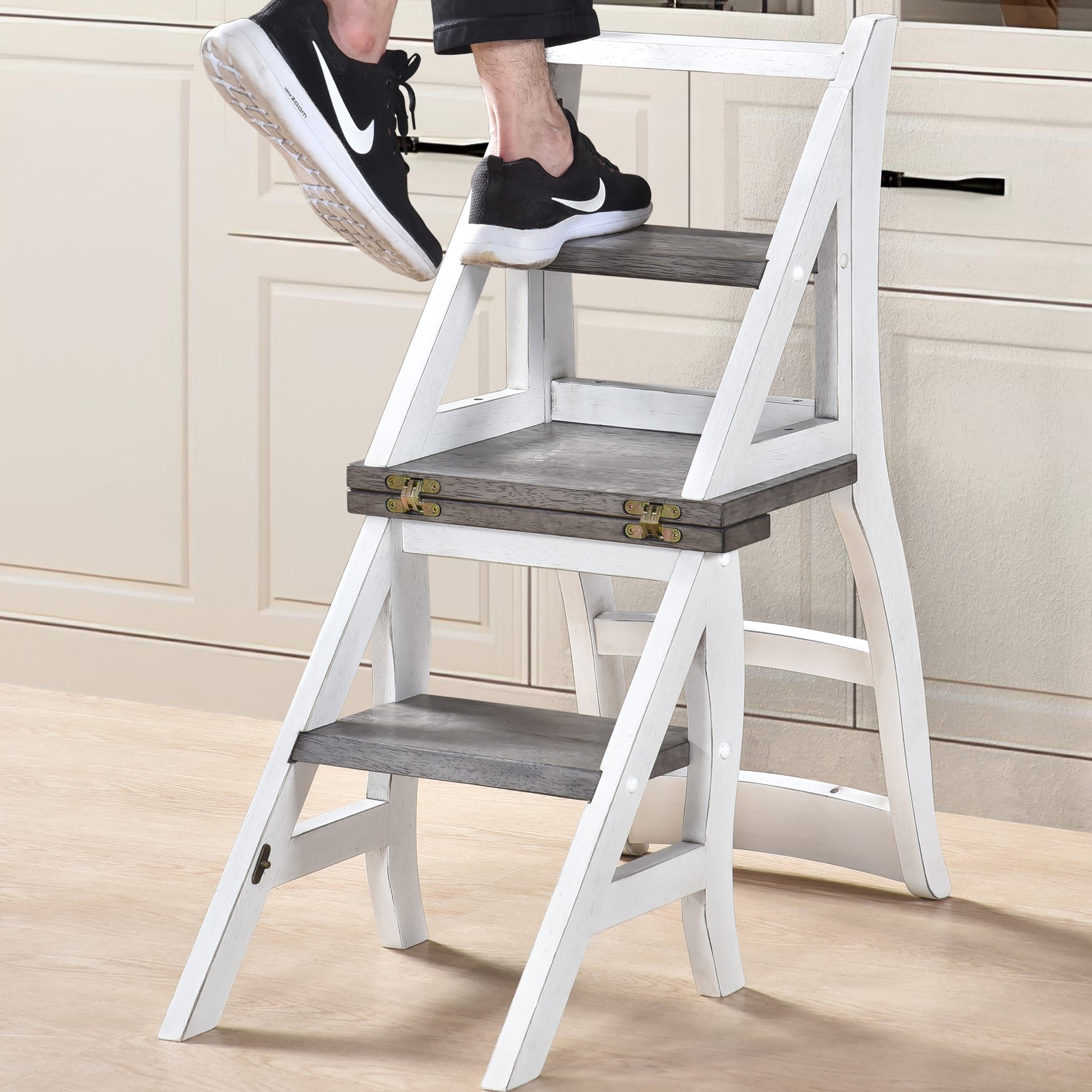White wooden step stool with distressed gray wood steps and gold hinges