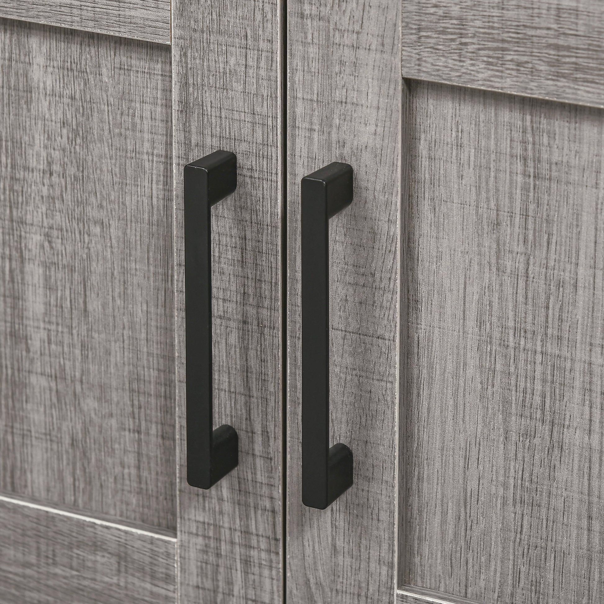 Closeup of distressed grey wood cabinet doors with black bar handles