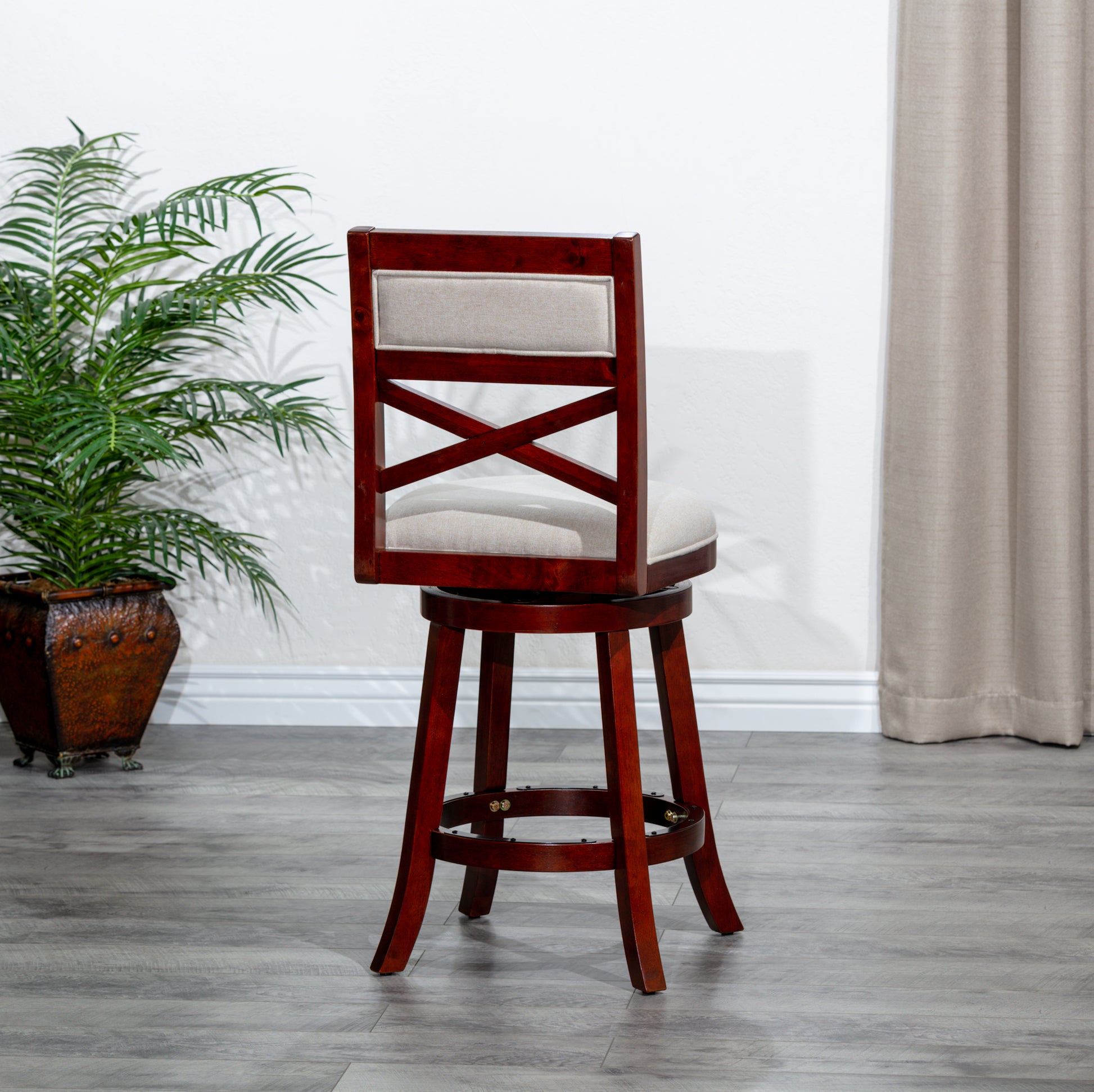 Swivel bar stool with dark cherry finish wood and upholstered beige seat