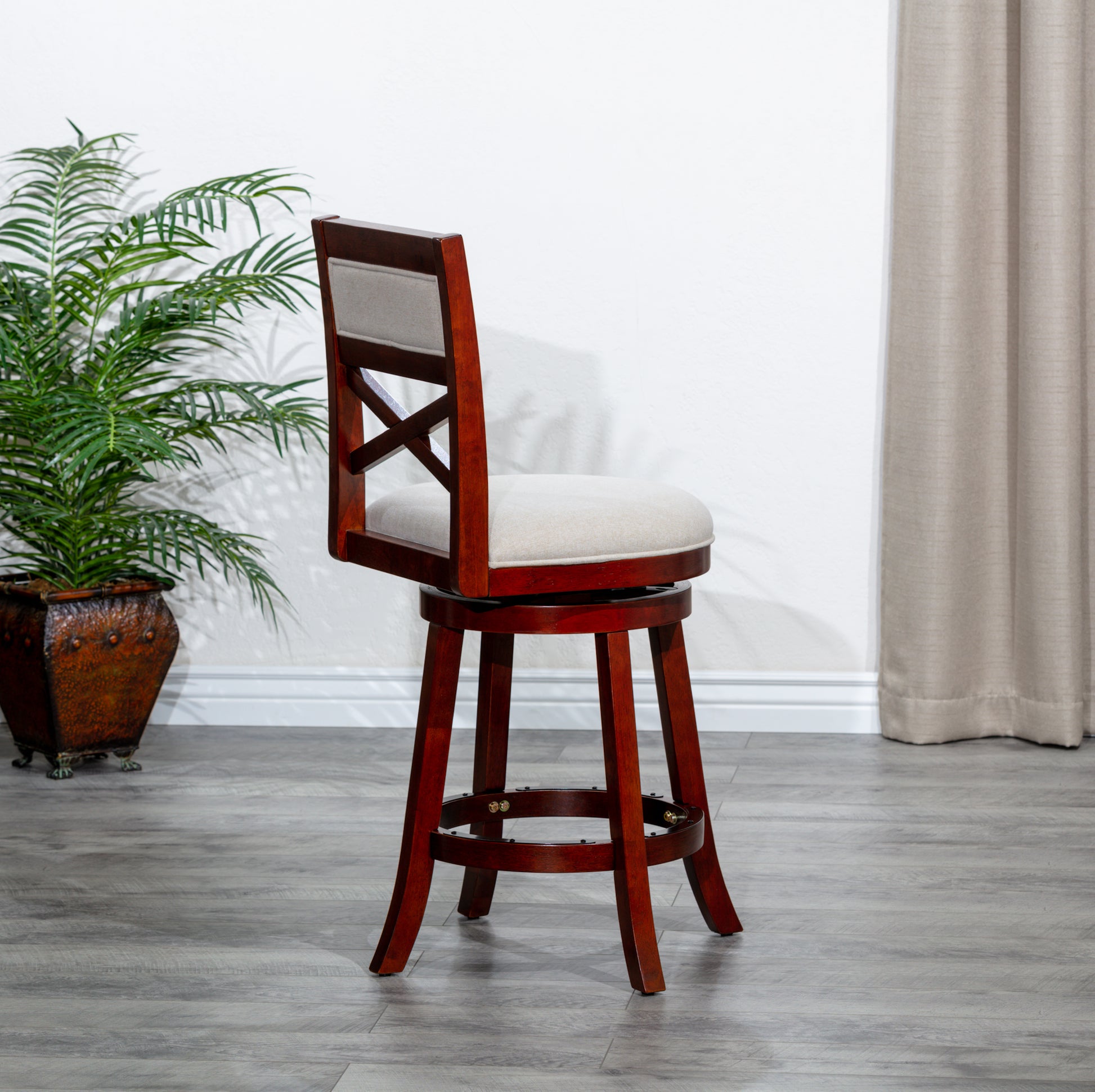 Cherry finish wood swivel bar stool with beige linen seat and Xback detail