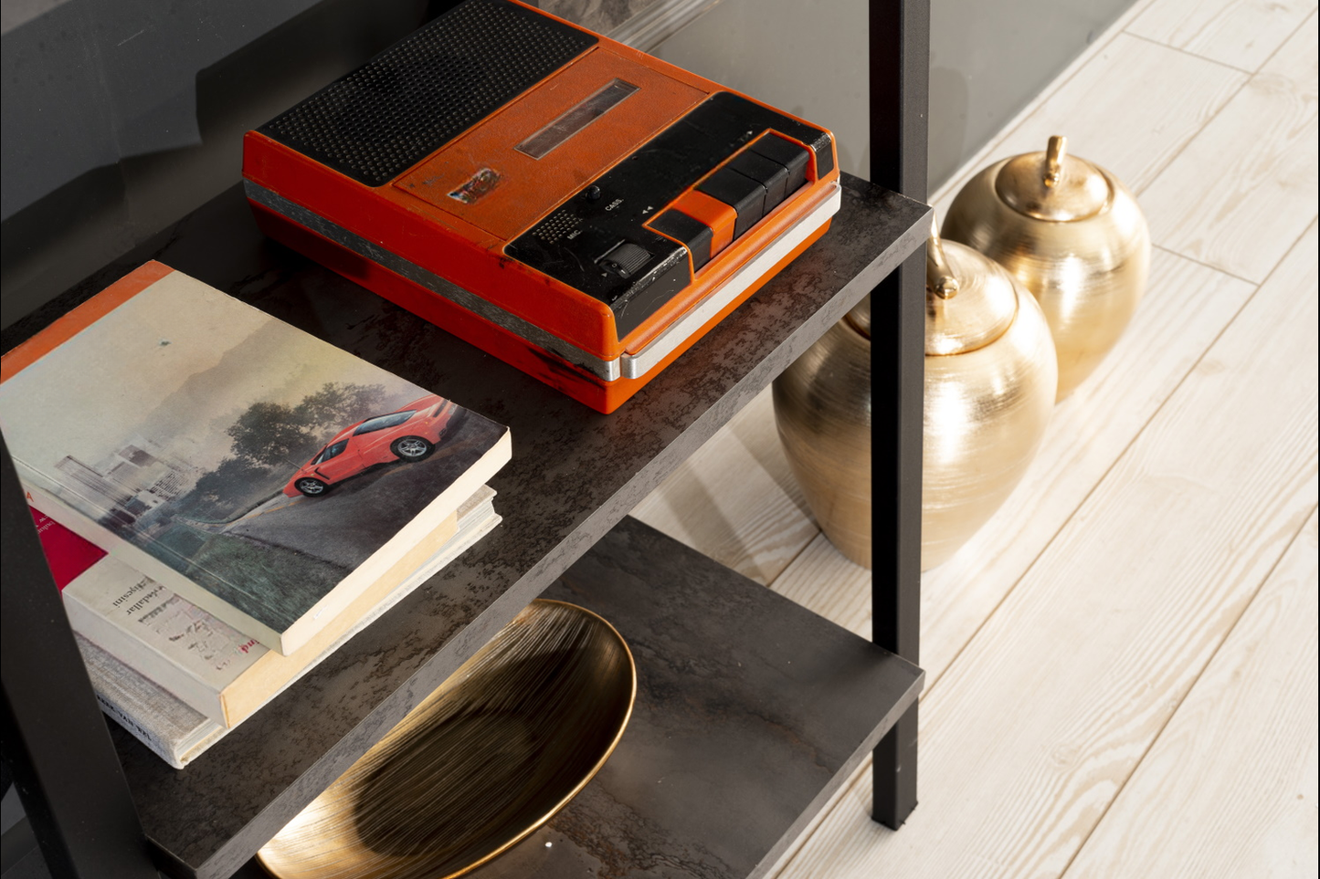 Retro orange cassette player with black details on a dark shelf vintage audio device