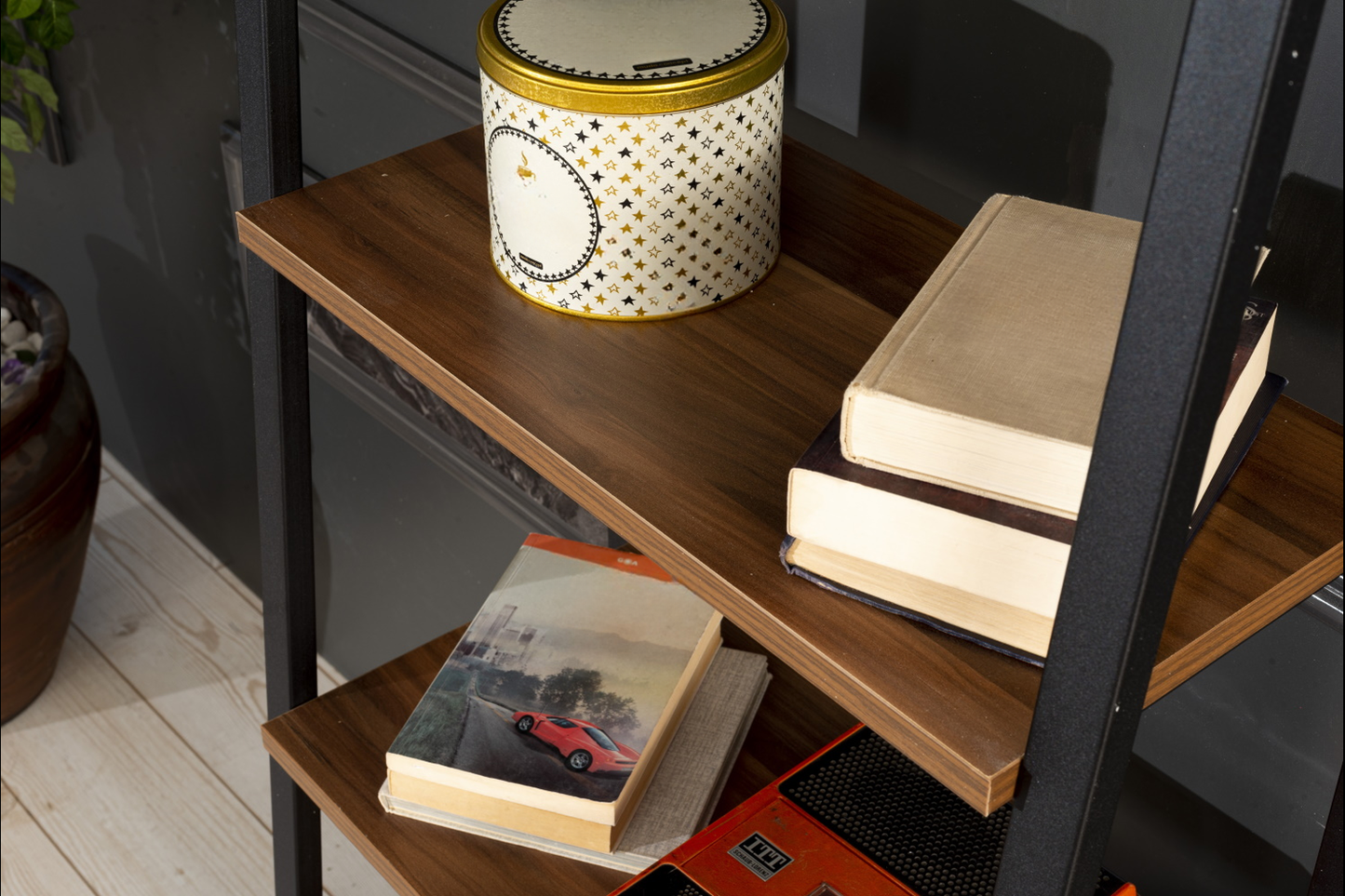 Gold and white decorative tin with star pattern on a wooden shelf